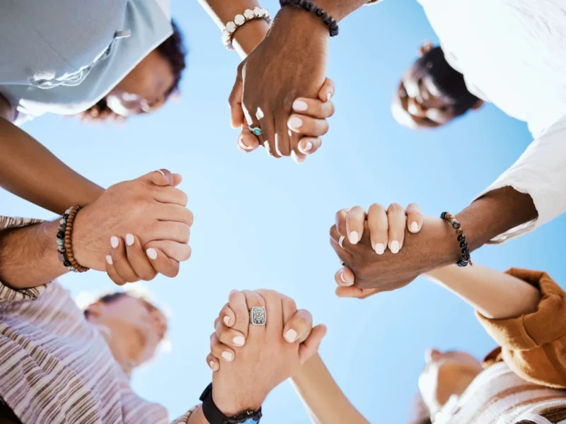 A group of people holding hands.