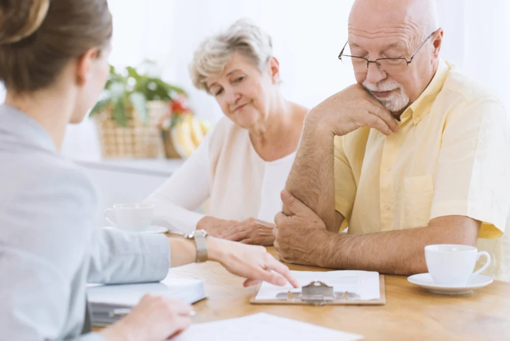 An elderly couple sat talking with their solicitor.